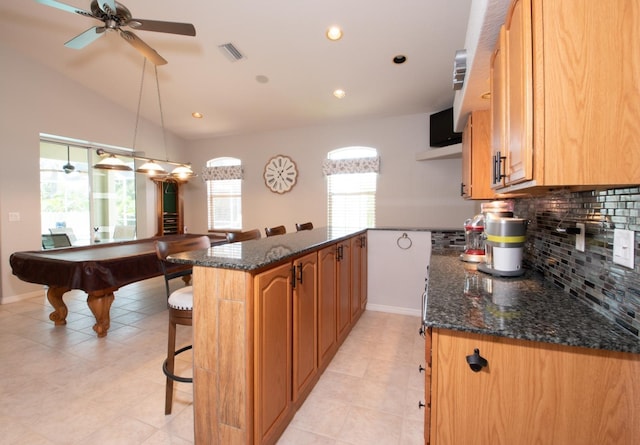 916 Bunker View Dr, Apollo Beach, FL 33572 - kitchen with a peninsula, decorative backsplash, a breakfast bar area, a ceiling fan, and dark stone countertops