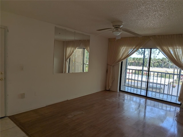 642 Bird Bay Dr E Unit 205, Venice, FL 34285 - empty room featuring a ceiling fan, a textured ceiling, and wood finished floors
