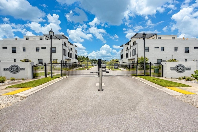 6210 64th Way N, Pinellas Park, FL 33781 - view of asphalt street featuring a gate, street lighting, sidewalks, and a gated entry