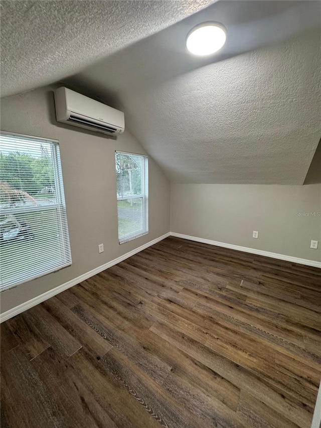 1512 7th St, Saint Cloud, FL 34769 - bonus room featuring an AC wall unit, a textured ceiling, vaulted ceiling, dark wood finished floors, and plenty of natural light