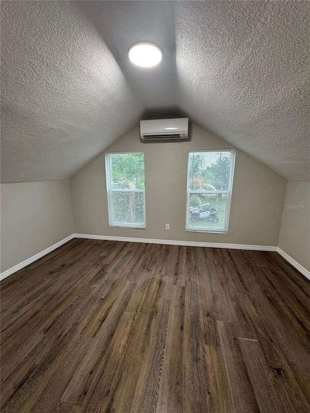 1512 7th St, Saint Cloud, FL 34769 - bonus room with a wall unit AC, a textured ceiling, wood finished floors, and vaulted ceiling