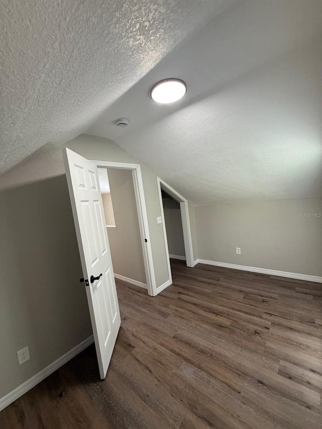 1512 7th St, Saint Cloud, FL 34769 - bonus room featuring a textured ceiling, dark wood finished floors, and vaulted ceiling
