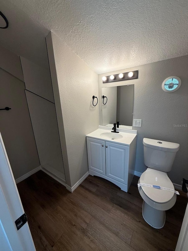 1512 7th St, Saint Cloud, FL 34769 - half bathroom featuring wood finished floors, vanity, a textured ceiling, and a textured wall