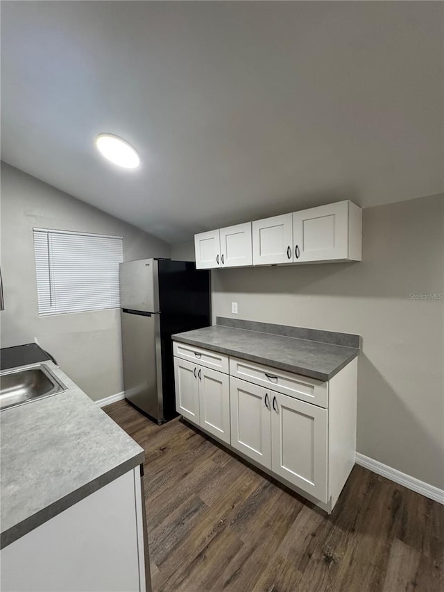 1512 7th St, Saint Cloud, FL 34769 - kitchen featuring freestanding refrigerator, vaulted ceiling, dark wood finished floors, and white cabinetry