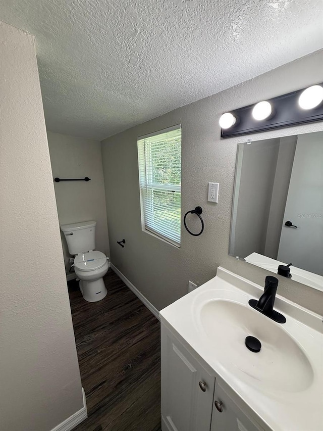 1512 7th St, Saint Cloud, FL 34769 - bathroom with a textured ceiling, vanity, wood finished floors, and a textured wall