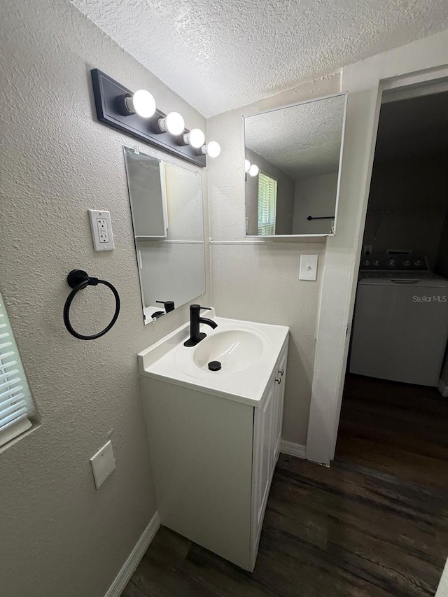 1512 7th St, Saint Cloud, FL 34769 - bathroom with washer / dryer, a textured ceiling, vanity, and wood finished floors