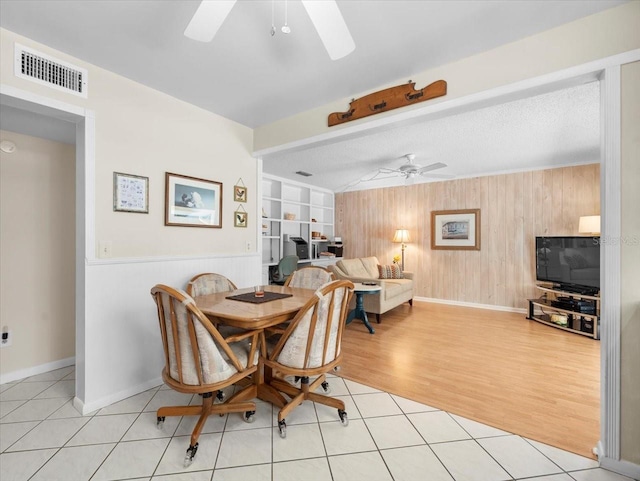 15711 Springmoss Ln, Tampa, FL 33624 - dining room with a ceiling fan, wood walls, light tile patterned floors, and built in features