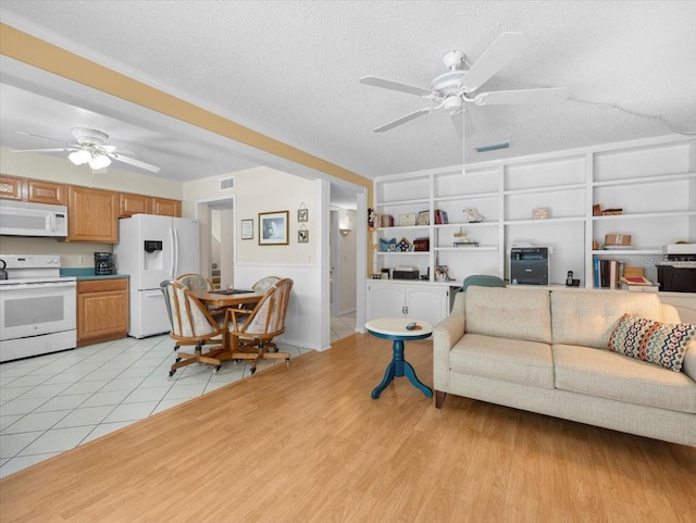 15711 Springmoss Ln, Tampa, FL 33624 - living area featuring a ceiling fan, a textured ceiling, light tile patterned flooring, and built in shelves