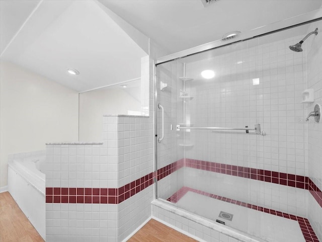 15711 Springmoss Ln, Tampa, FL 33624 - bathroom with a stall shower, wood finished floors, and a bath