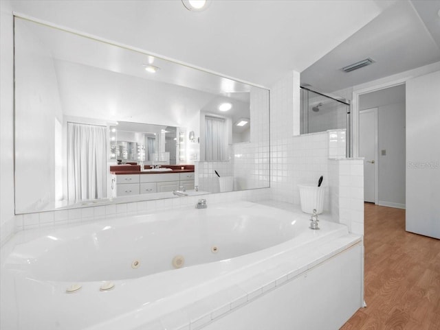 15711 Springmoss Ln, Tampa, FL 33624 - bathroom featuring a whirlpool tub, vanity, a shower stall, and wood finished floors