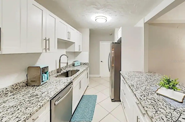 4505 S Clark Ave, Tampa, FL 33611 - kitchen with stainless steel appliances, white cabinets, light stone countertops, and light tile patterned floors