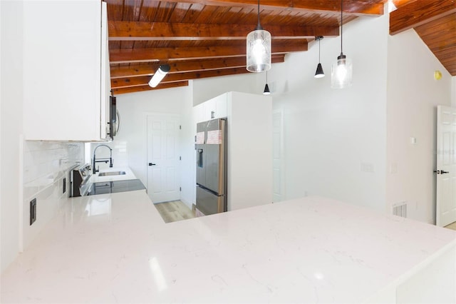 9445 Cardy St, New Port Richey, FL 34654 - kitchen with appliances with stainless steel finishes, wooden ceiling, light stone countertops, white cabinetry, and hanging light fixtures