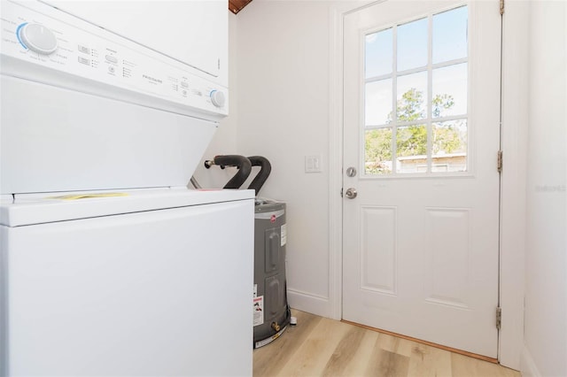 9445 Cardy St, New Port Richey, FL 34654 - laundry room with stacked washing machine and dryer and light wood-style floors