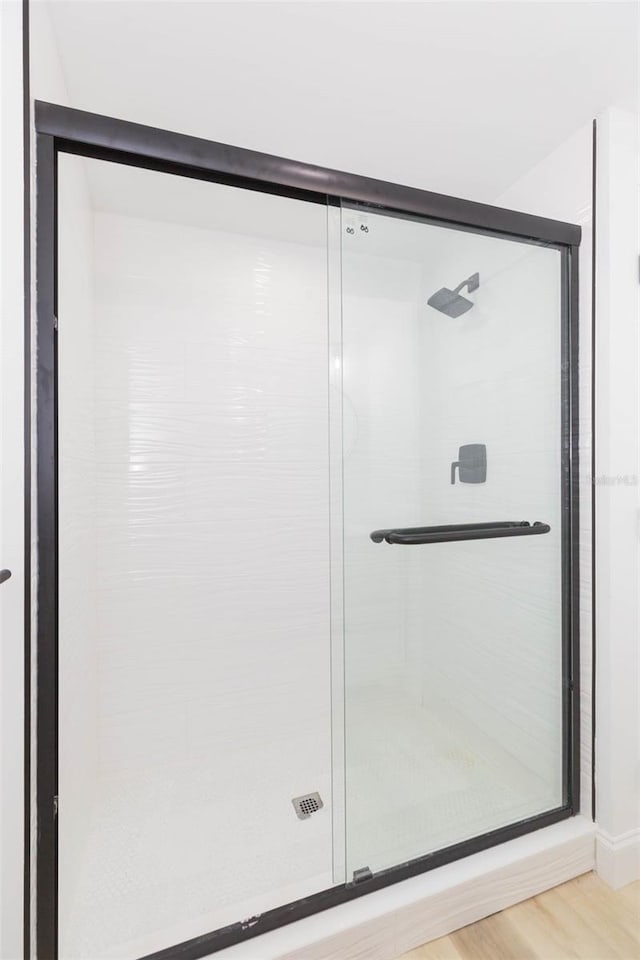 9445 Cardy St, New Port Richey, FL 34654 - bathroom featuring a stall shower and wood finished floors