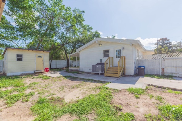 9445 Cardy St, New Port Richey, FL 34654 - rear view of property with a patio area, a fenced backyard, and an outbuilding