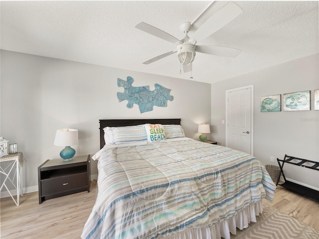 19440 Gulf Blvd Unit 301, Indian Rocks Beach, FL 33785 - bedroom featuring light wood-style flooring, a textured ceiling, and a ceiling fan