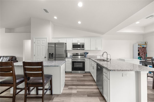 231 Marion Oaks Trl, Ocala, FL 34473 - kitchen featuring stainless steel appliances, a breakfast bar, a peninsula, white cabinetry, and light wood-style flooring