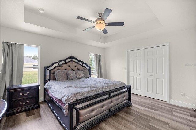 231 Marion Oaks Trl, Ocala, FL 34473 - bedroom with a tray ceiling, wood finished floors, ceiling fan, and a closet