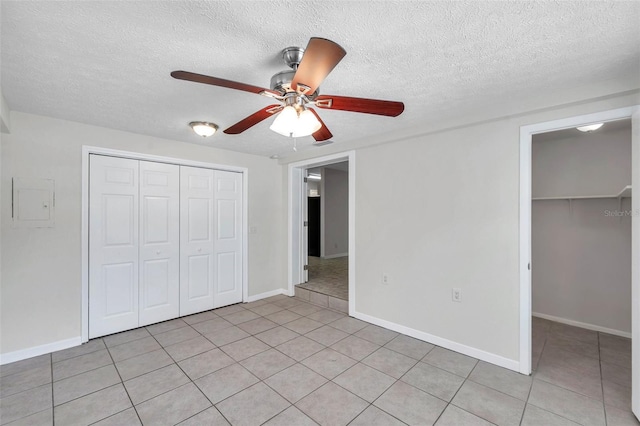 2509 W Crawford St, Tampa, FL 33614 - unfurnished bedroom featuring a closet, light tile patterned floors, a textured ceiling, a ceiling fan, and a spacious closet