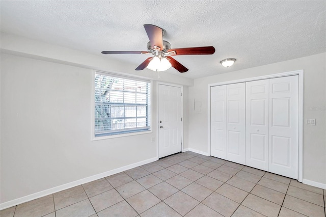 2509 W Crawford St, Tampa, FL 33614 - unfurnished bedroom featuring light tile patterned flooring, a closet, a textured ceiling, and ceiling fan