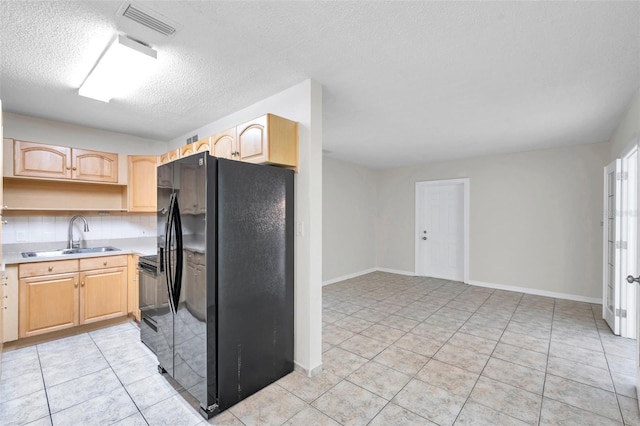 2509 W Crawford St, Tampa, FL 33614 - kitchen featuring freestanding refrigerator, light brown cabinets, a textured ceiling, light tile patterned flooring, and light countertops