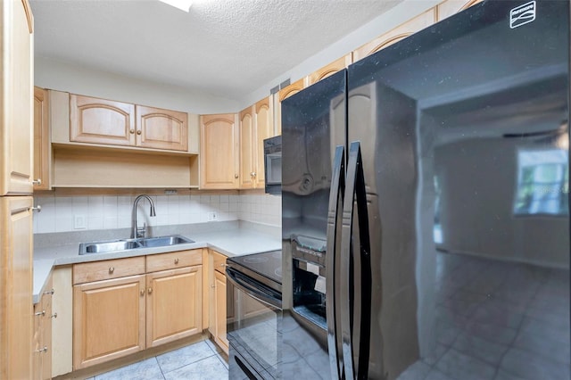 2509 W Crawford St, Tampa, FL 33614 - kitchen featuring black appliances, light brown cabinets, decorative backsplash, and a textured ceiling