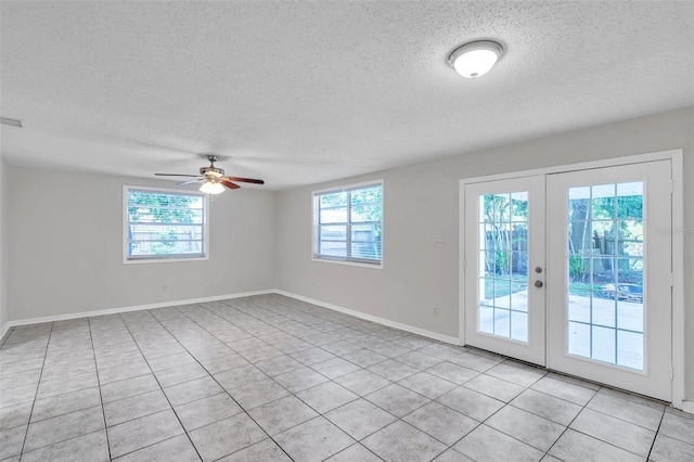 2509 W Crawford St, Tampa, FL 33614 - spare room featuring healthy amount of natural light, a textured ceiling, light tile patterned floors, a ceiling fan, and french doors