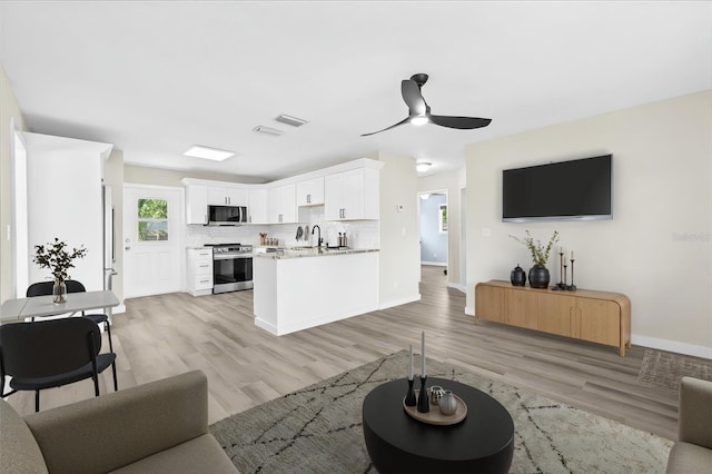 4718 W Oklahoma Ave, Tampa, FL 33616 - living room featuring a ceiling fan and light wood finished floors