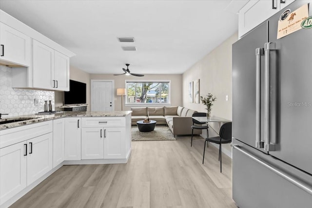 4718 W Oklahoma Ave, Tampa, FL 33616 - kitchen featuring high end fridge, ceiling fan, light wood finished floors, backsplash, and white cabinetry