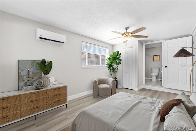 4718 W Oklahoma Ave, Tampa, FL 33616 - bedroom with an AC wall unit, light wood-type flooring, ensuite bath, and a ceiling fan