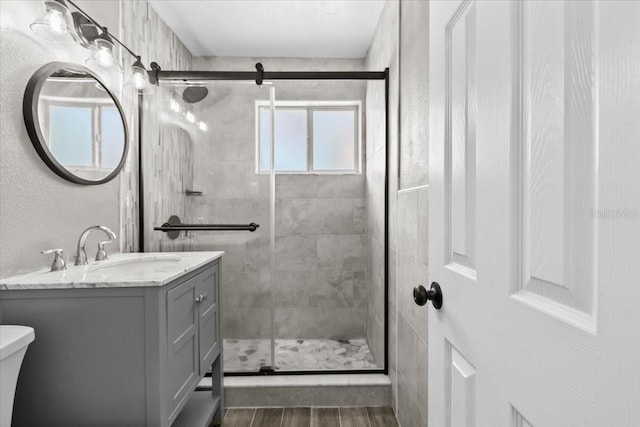 4718 W Oklahoma Ave, Tampa, FL 33616 - full bath featuring vanity, a shower stall, and wood finished floors