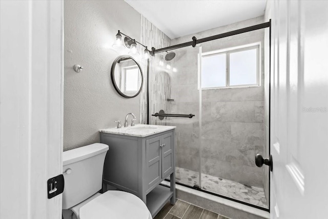 4718 W Oklahoma Ave, Tampa, FL 33616 - full bathroom with vanity, tiled shower, a textured wall, and wood finished floors
