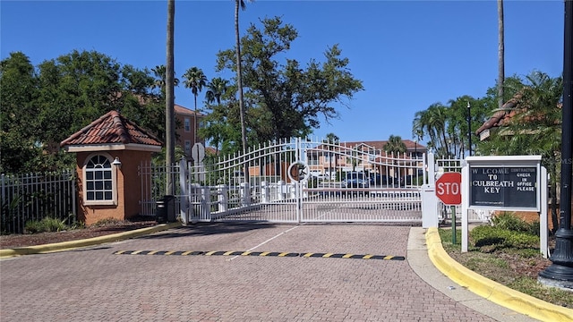 5000 Culbreath Key Way Unit 1-220, Tampa, FL 33611 - view of decorative road featuring traffic signs, curbs, a gate, and a gated entry