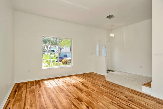 1734 Mapleleaf Blvd, Oldsmar, FL 34677 - unfurnished room featuring light wood-type flooring and a chandelier