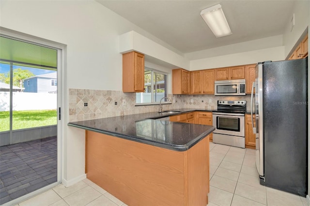 1734 Mapleleaf Blvd, Oldsmar, FL 34677 - kitchen with stainless steel appliances, a peninsula, light tile patterned floors, and tasteful backsplash