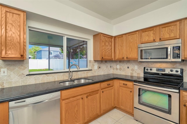 1734 Mapleleaf Blvd, Oldsmar, FL 34677 - kitchen with stainless steel appliances, decorative backsplash, light tile patterned floors, and dark stone countertops