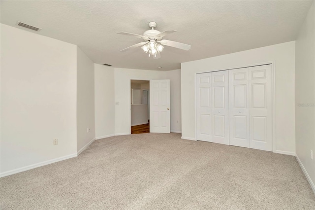 1734 Mapleleaf Blvd, Oldsmar, FL 34677 - unfurnished bedroom with light carpet, a closet, a textured ceiling, and ceiling fan