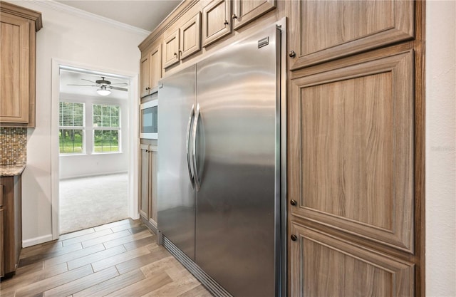 6728 Sutton Oaks Ln, Zephyrhills, FL 33541 - kitchen with appliances with stainless steel finishes, crown molding, light wood-style flooring, ceiling fan, and light stone counters