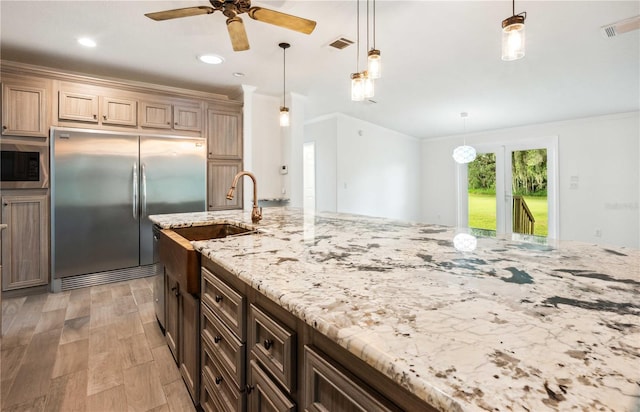 6728 Sutton Oaks Ln, Zephyrhills, FL 33541 - kitchen featuring built in appliances, ceiling fan, light stone counters, ornamental molding, and light wood-style flooring