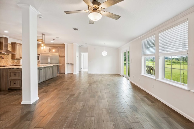 6728 Sutton Oaks Ln, Zephyrhills, FL 33541 - unfurnished living room with dark wood finished floors, ceiling fan, and ornate columns