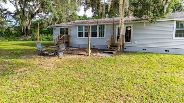 6728 Sutton Oaks Ln, Zephyrhills, FL 33541 - rear view of house featuring crawl space, a lawn, and an outdoor fire pit