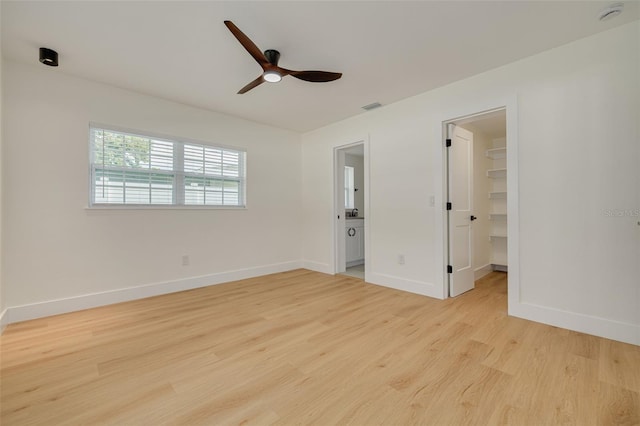 1723 Cypress Ave, Belleair, FL 33756 - unfurnished bedroom featuring light wood-style flooring, a walk in closet, ceiling fan, a closet, and ensuite bath