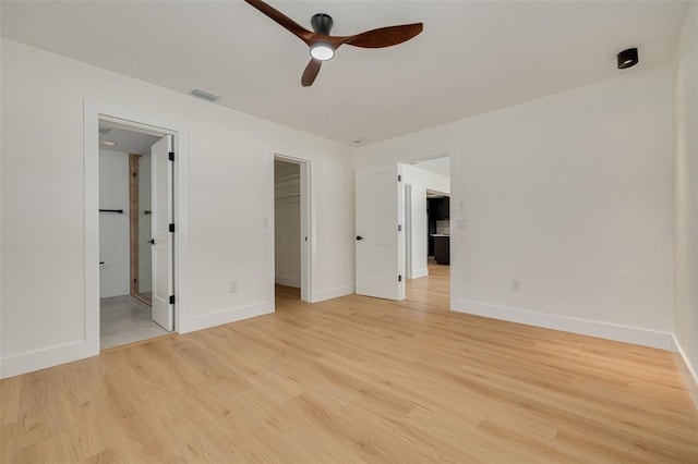 1723 Cypress Ave, Belleair, FL 33756 - unfurnished bedroom featuring light wood-style floors, a walk in closet, connected bathroom, ceiling fan, and a closet