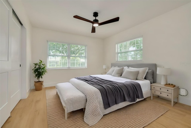 1723 Cypress Ave, Belleair, FL 33756 - bedroom with multiple windows, light wood finished floors, a closet, and a ceiling fan