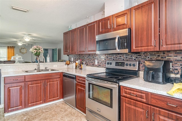 1827 Peaceful Palm St, Ruskin, FL 33570 - kitchen featuring stainless steel appliances, ceiling fan, decorative backsplash, a peninsula, and a textured ceiling