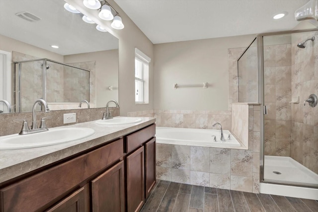 11309 Langworth Hill Ln, Riverview, FL 33579 - bathroom featuring a garden tub, a shower stall, double vanity, and wood finished floors