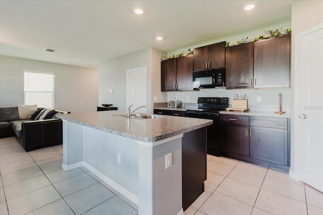 17156 Yellow Pine St, Wimauma, FL 33598 - kitchen with black appliances, light tile patterned flooring, open floor plan, dark brown cabinets, and recessed lighting