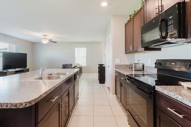 17156 Yellow Pine St, Wimauma, FL 33598 - kitchen with black appliances, ceiling fan, light tile patterned flooring, open floor plan, and an island with sink