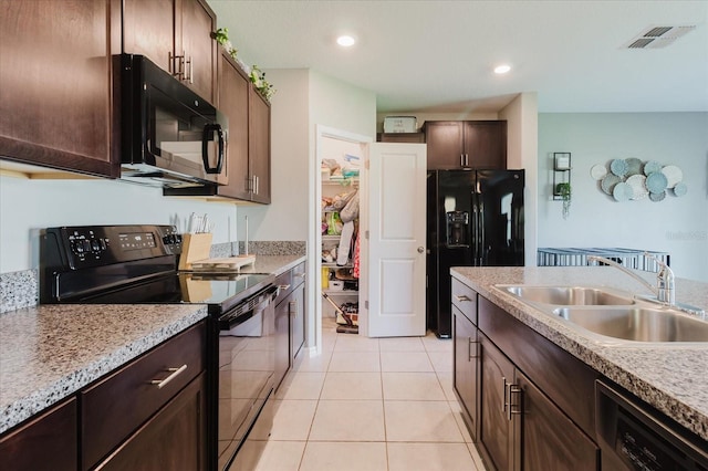 17156 Yellow Pine St, Wimauma, FL 33598 - kitchen with black appliances, light tile patterned floors, dark brown cabinetry, light countertops, and recessed lighting