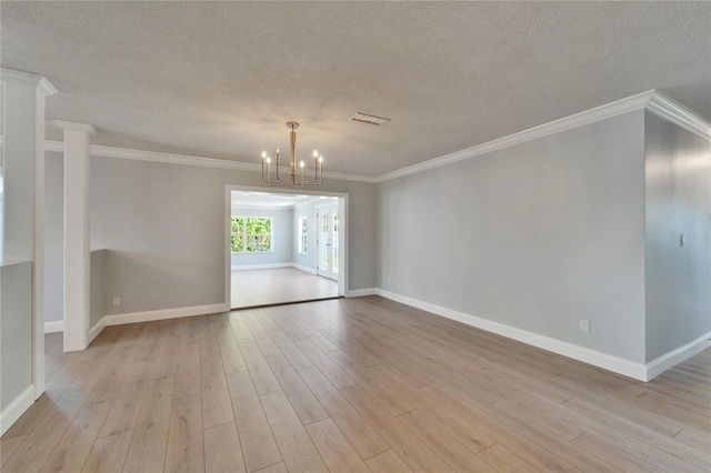 4518 Helena St NE, Saint Petersburg, FL 33703 - unfurnished room with light wood-type flooring, a chandelier, a textured ceiling, and crown molding